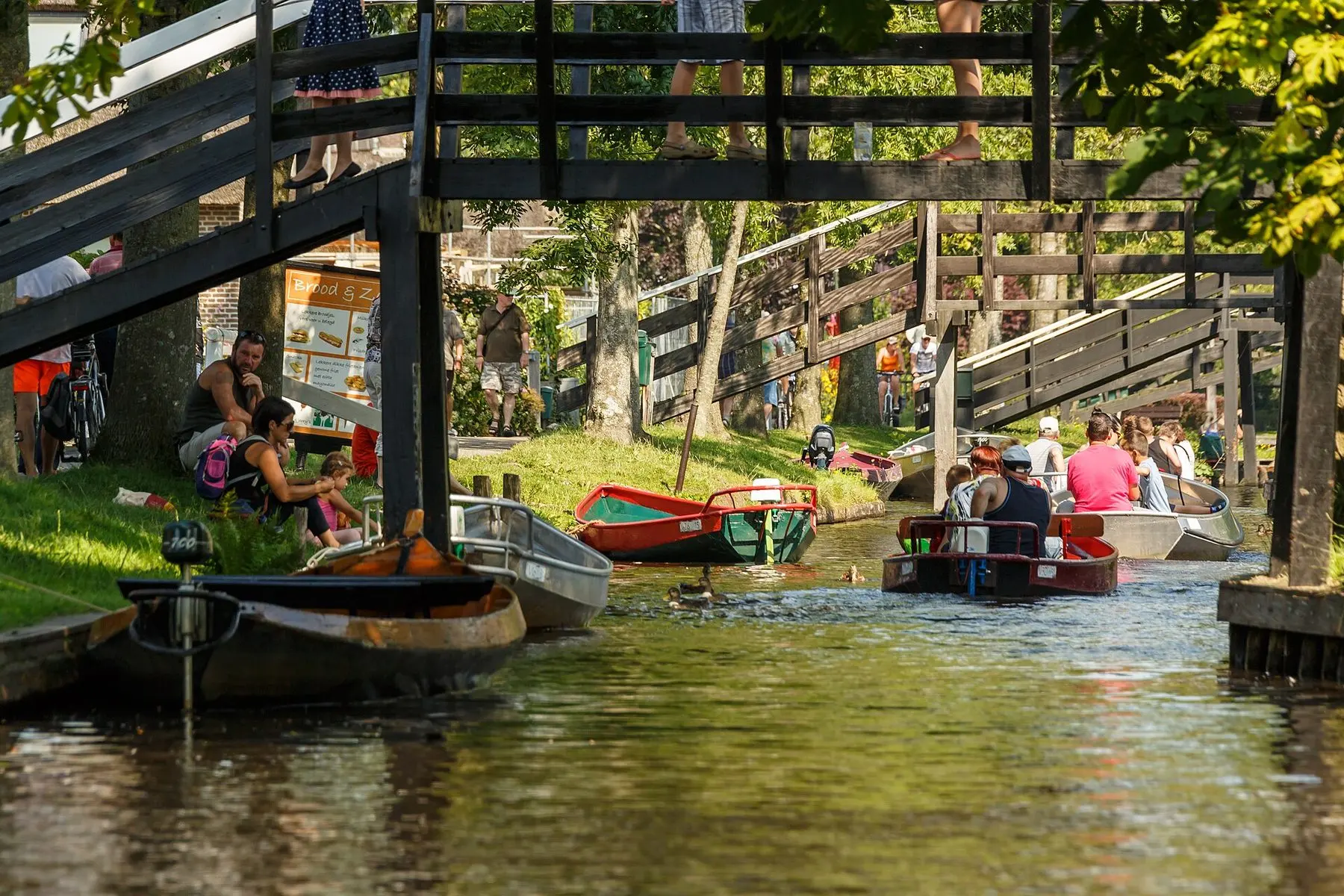 Fattoria con tetto di paglia accanto a un canale a Giethoorn con un piccolo ponte pedonale
