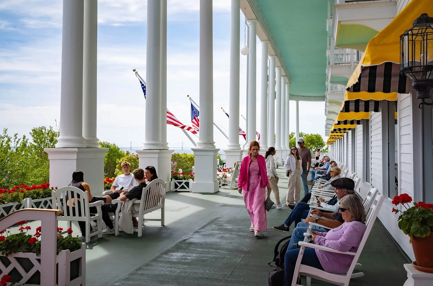 Una carrozza trainata da cavalli su Main Street, isola di Mackinac, con il porto e i traghetti sullo sfondo