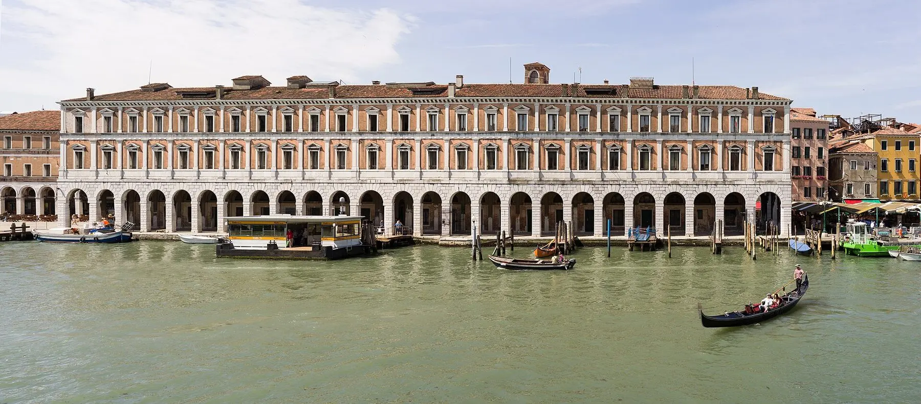 Gondoles et un vaporetto sur un canal de Venise bordé de bâtiments historiques