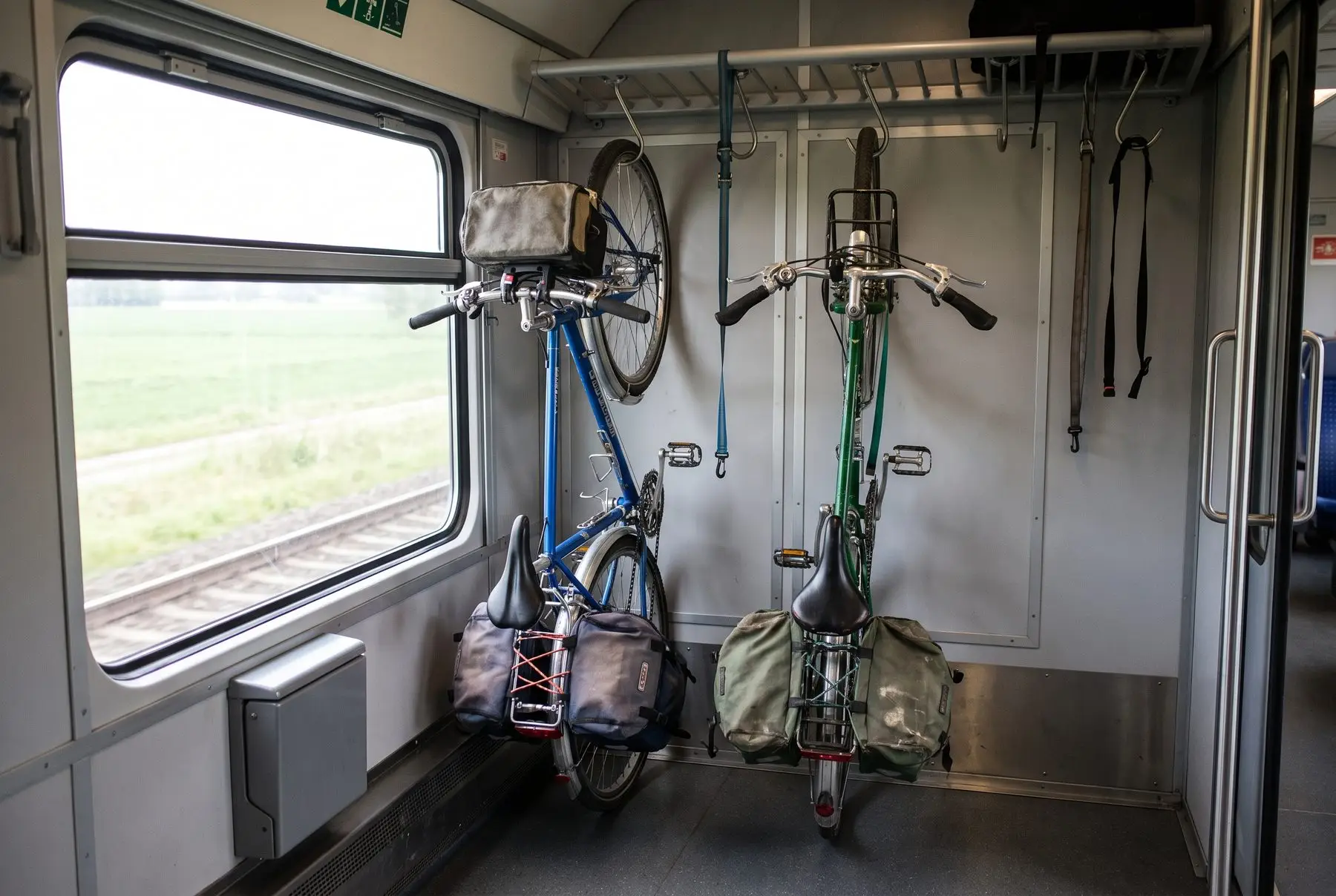 Uma bicicleta de viagem em um vagão dedicado a bicicletas ao lado da janela do trem